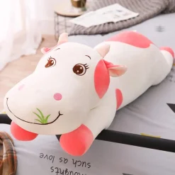 Peluche vache coloré qui broute de l'herbe
