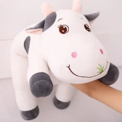 Peluche vache coloré qui broute de l'herbe